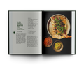 Open cookbook showing a recipe for whole roasted fish with side dishes.